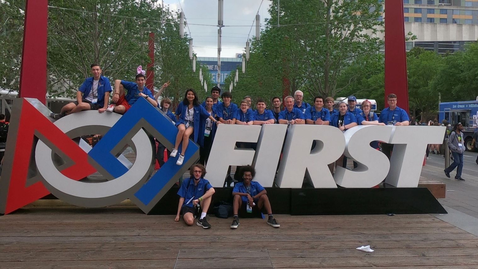 Group photo in front of FIRST sign.