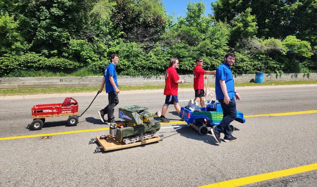 Students driving robots in the Memorial Day parade.