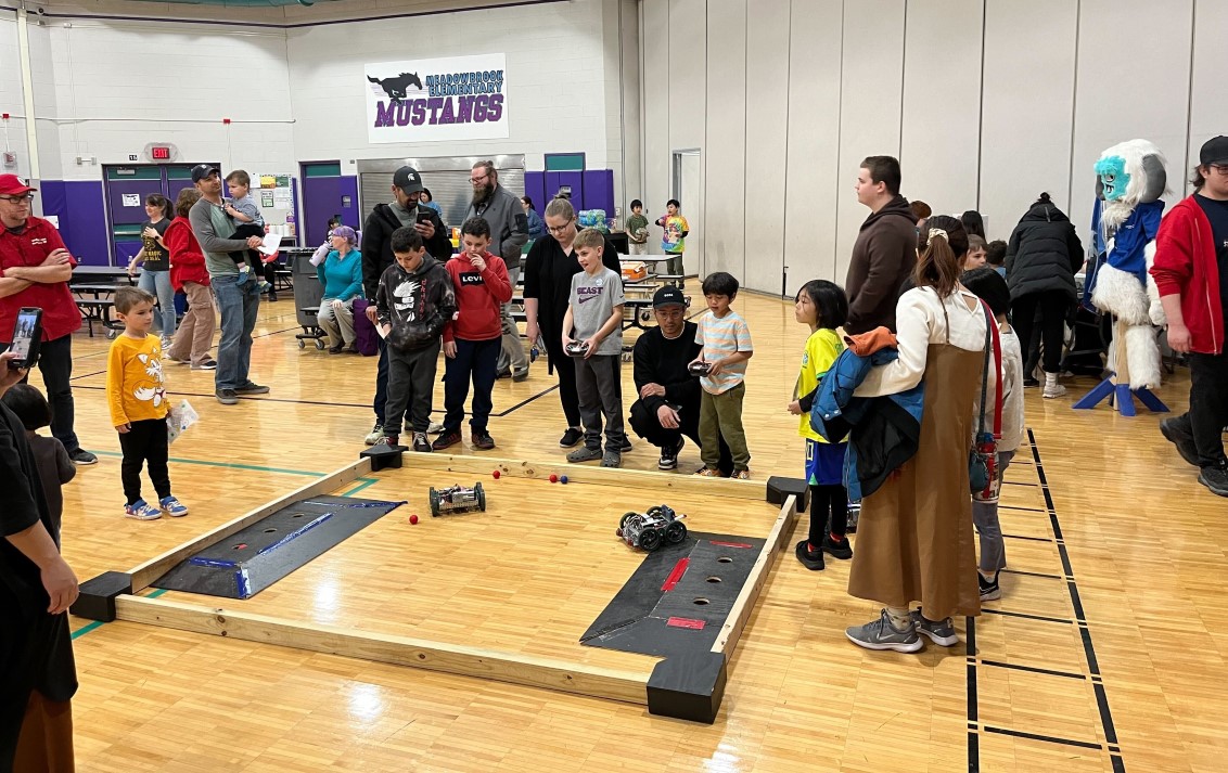 Kids playing with small VEX robots at STEM night.